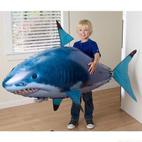 Tap Once remote control flying shark balloon toy being held by a young boy in a living room